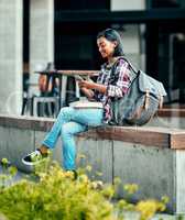 Texting her classmates to join her. Shot of a young female student using a cellphone outside on campus.