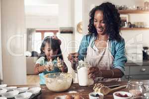 Family is the music that brings harmony. Shot of a woman baking at home with her young daughter.