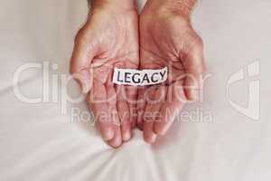 Whats your story. Cropped shot of a person holding a piece of paper with the word legacy written on it.