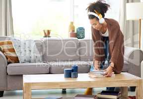 If you did some cleaning, it was a productive day. Shot of a woman wearing headphones while busy cleaning at home.