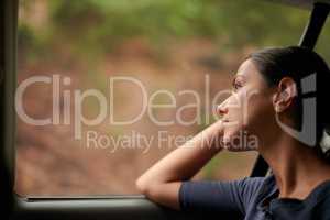 A long journey ahead. A beautiful woman looking out of a car window.