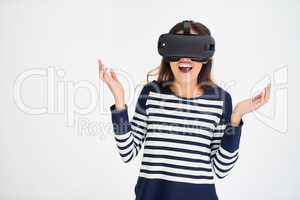 This is so unreal. Studio shot of a young woman looking amazed while wearing a VR headset against a white background.