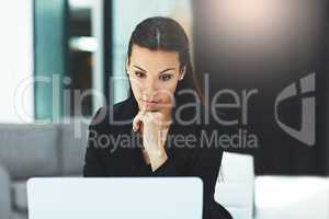 Dont ever lose your focus. Shot of a focussed young businesswoman working on her laptop in the office.