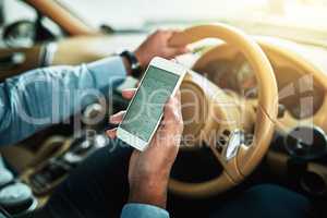 Doing a quick check in with his schedule. Closeup shot of an unrecognisable businessman using a cellphone while driving.