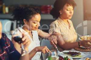 Shes the top carnivore in the group. Shot of a group of friends enjoying a meal and drinks together around a table at a gathering outdoors.