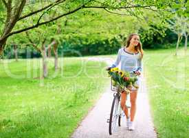 The scenic route is always better. Shot of a young woman cycling in the park.