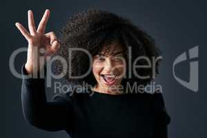 Being happy changes your world. Shot of a young businesswoman making hand gestures against a studio background.