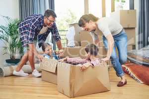 Getting the family involved boosts family morale. Shot of a happy family having fun together on moving day.