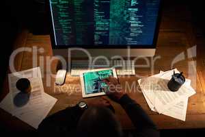 Coding on multiple platforms. High angle shot of an unrecognizable man coding on his tablet in the office.