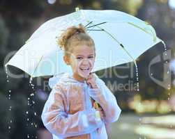 Time to get up to some mischief. Shot of a little girl playfully standing in the rain holding her umbrella.