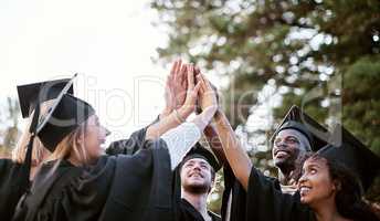 Pursuing a bright future. Shot of a group of students giving each other a high five on graduation day.