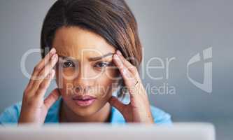 I seriously need a timeout. Shot of an attractive young woman experiencing stress while using a laptop at home.