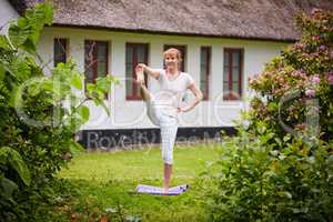 She loves a full mind and body workout. Shot of a woman practicing yoga in her backyard.