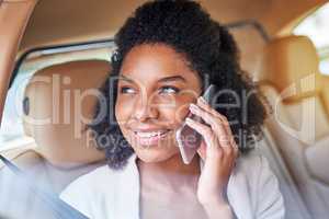 Lets set up a meeting. Shot of an attractive young businesswoman making a phonecall while being driven to work on her morning commute.