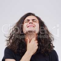 Someone come save me. Studio shot of a young man suffering with a sore throat against a grey background.