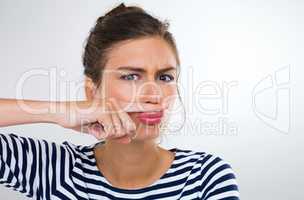 Theyll never find me with this disguise. Portrait of a beautiful young woman using her finger to make a moustache.