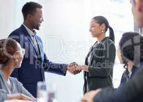 Congratulations. Cropped shot of two white collar businesspeople shaking hands while standing in the boardroom during a meeting.