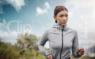 Keep your lead ahead of the pact. Shot of a sporty young woman running outdoors.