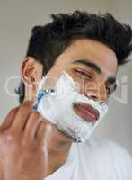 No shave November is done. Shot of a handsome young man shaving his facial hair in the bathroom.