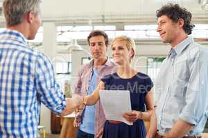 Every beginning comes from some other beginnings end. Shot of a businesspeople shaking hands in an office.