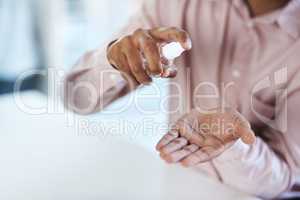 Germs may seem invisible, but they are there. Closeup shot of an unrecognisable businessman using hand sanitiser in an office.