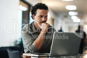 I know I can make this better. Shot of a handsome young businessman sitting alone in the office and looking contemplative while using his laptop.