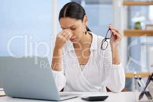 I cant think anymore. Shot of a young businesswoman sitting at a desk looking overwhelmed in a modern office.