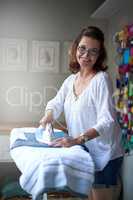 Getting rid of wrinkles and creases. Portrait of a mature woman ironing a shirt.