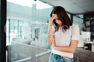 Workplace stress is a major risk factor for anxiety and depression. Shot of a young businesswoman looking stressed out in an office.