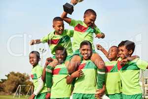 Play with passion and you will win. Shot of a boys soccer team celebrating their victory on a sports field.