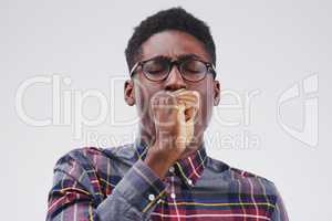 Coming down with the flu. Studio shot of a handsome young man coughing against a grey background.
