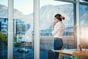 Looking out over her fashion empire. Cropped shot of an attractive young fashion designer enjoying a coffee while taking a break in her design studio.