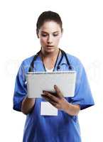 Digital diagnosis. Studio shot of a beautiful young doctor using a digital tablet against a white.