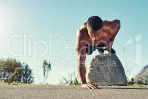 Adding some difficulty to my push up routine today. Shot of a handsome young man doing push ups outdoors.