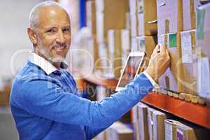 Rest assured your order is well taken care of. Portrait of a mature man working inside in a distribution warehouse.