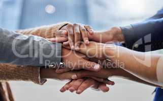 We have to motivate each other. Shot of a group of people with their hands stacked.