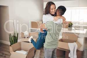 Owning your own house is the best feeling ever. Shot of a couple looking cheerful while moving into their new home.