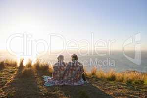 Sharing a sweet moment. View of a senior couple sitting on a hillside together.