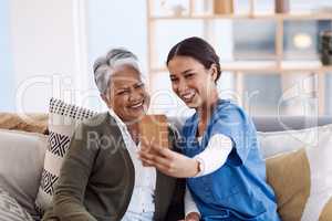 Adding some fun to their days together. Shot of a young nurse taking selfies with a senior woman in a retirement home.