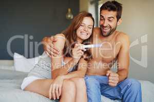 I cant wait to start a family with you. Shot of a young couple looking at the results on a pregnancy test.