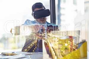 Business from a brand new perspective. Multiple exposure shot of a businessman wearing a VR headset while working in his office.