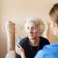 Thoughts of days gone by. Shot of a nurse caring for an elderly woman at a nursing home.