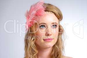 Delicate beauty. Studio shot of a beautiful young woman wearing a feathered headband.