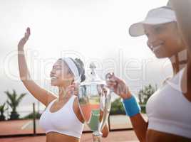 United we play, United we win. Shot of two young tennis players holding up a trophy.