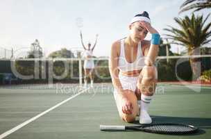 I hate to lose more than I love to win. Shot of a young woman looking disappointed after a tennis match.