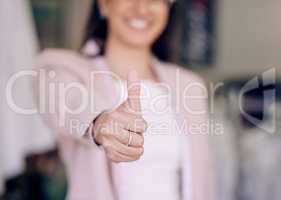 You are right where you need to be. Shot of a seamstress giving thumbs up while working in her boutique.