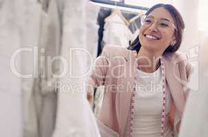 Youll surely find something you like in my store. Shot of an attractive young seamstress working in a bridal boutique.