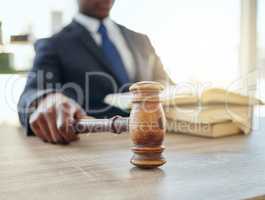 Im not afraid to use it. Shot of an unrecognizable lawyer using a gavel at work.