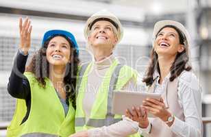 Envisioning the final product. Cropped shot of three attractive female engineers using a tablet while working on a construction site.