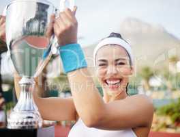 On and off the court, Im winning. Shot of an attractive young tennis player holding up a trophy.